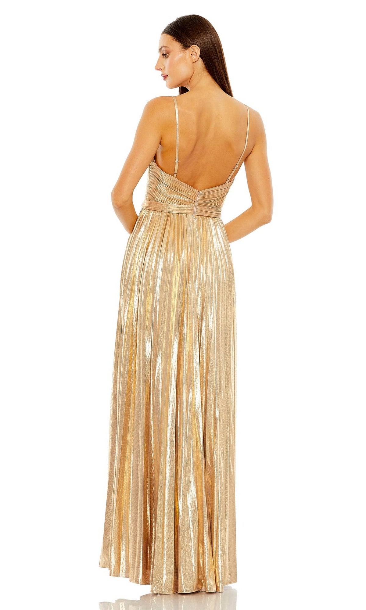 A woman stands with her back to the camera, wearing the Long Formal Dress 27489 by Mac Duggal—a gold metallic, floor-length, pleated A-line dress with thin straps and an open back.